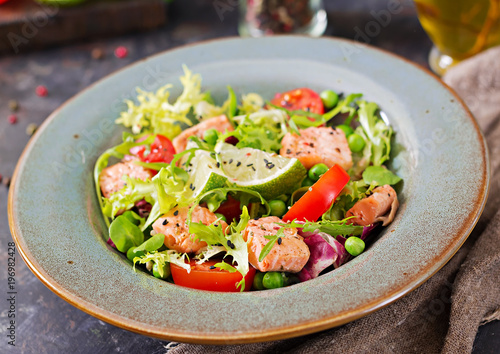 Healthy salad with fish. Baked salmon, tomatoes, lime and lettuce. Healthy dinner.