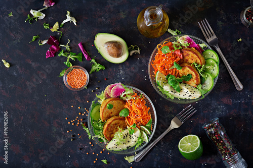 Vegan buddha bowl dinner food table. Healthy food. Healthy vegan lunch bowl. Fritter with lentils and radish, avocado, carrot salad. Flat lay. Top view