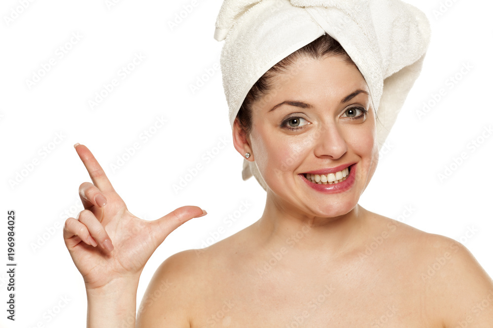 Young beautiful woman with towel on hr head on white background showing gun with her fingers Young beautiful woman with towel on hr head on white background showing gun with her fingers