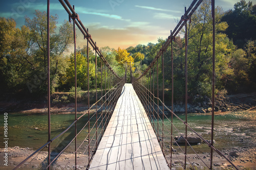 Suspension bridge over the mountain river