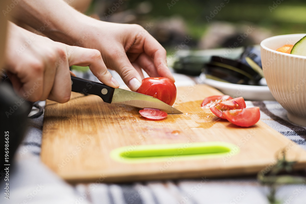 Unrecognizable teenagers camping and cooking. Unrecognizable teenagers camping and cooking.