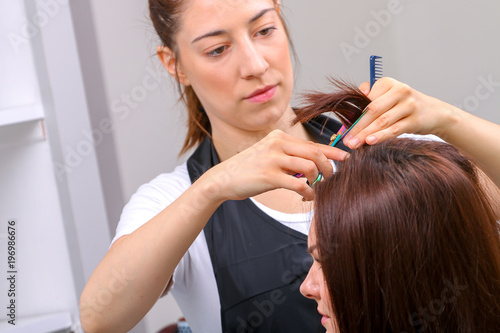 Close-up of a hairdresser cutting the hair of a woman in a beauty salon