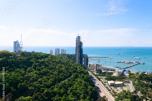 Thailand aerial high view from Pattaya buildings, park, ocean beach and condominiums. Downtown with blue clear sky. Sunny day, ocean beach and many ships.