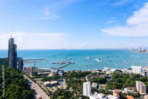 Thailand aerial high view from Pattaya buildings, park, ocean beach and condominiums. Downtown with blue clear sky. Sunny day, ocean beach and many ships.