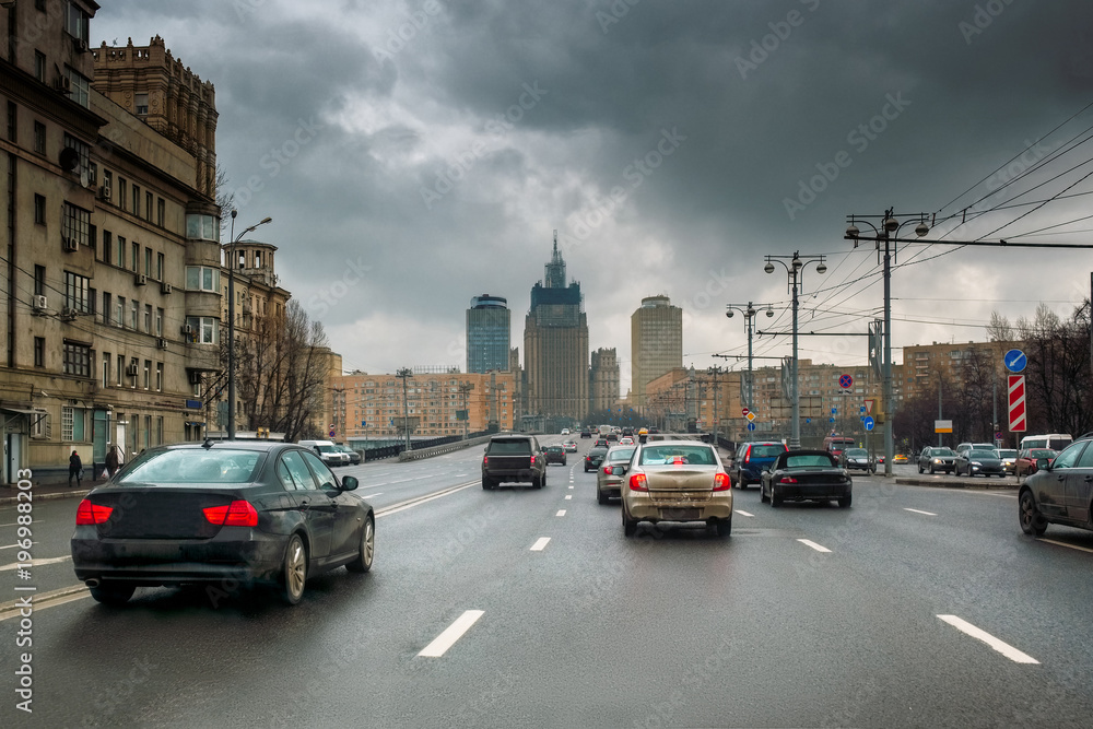 Traffic in a rainy spring Moscow. Dark stormy clouds. Contrasting sky. Dirty cars on the road