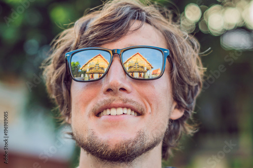 Male tourist looking at Thai temple in Phuket Town Wat Mongkolnimit photo