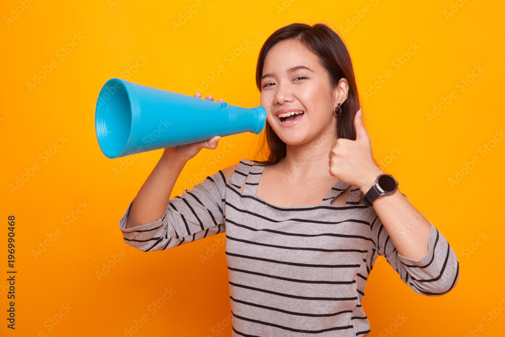 Beautiful young Asian woman show thumbs up announce with megaphone. Beautiful young Asian woman show thumbs up announce with megaphone.