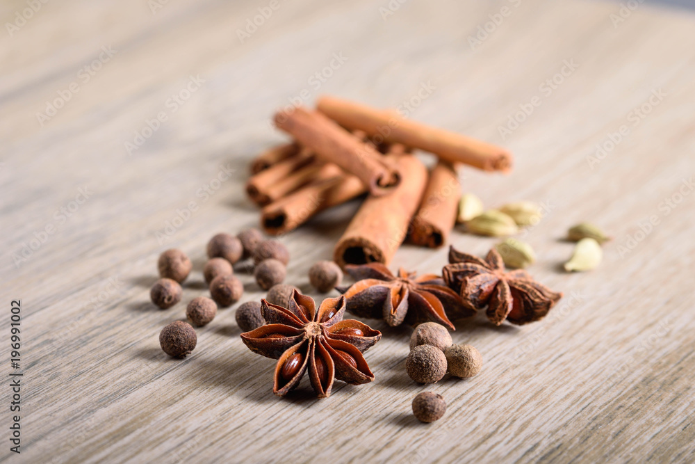 Various Spices background. Cinnamon sticks and anise stars close-up on wood background Various Spices background. Cinnamon sticks and anise stars close-up on wood background