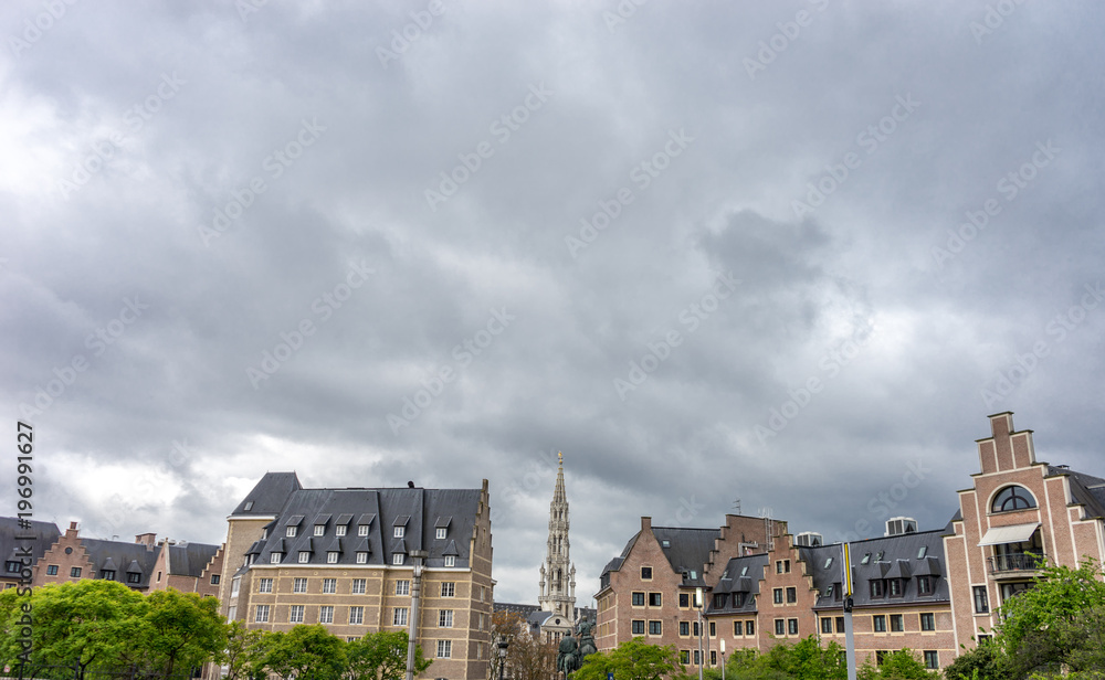The tall belfry Tower beneath gray clouds in the city of Brussels, Belgium