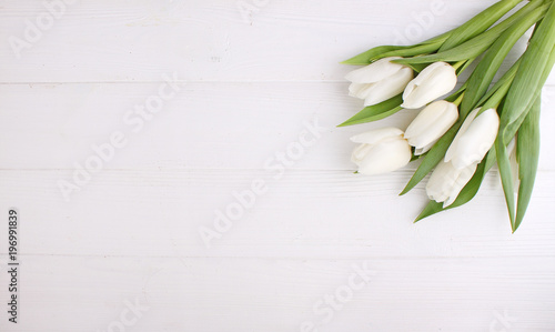 Bouquet of white tulips on a white wooden table  copy space. Easter.