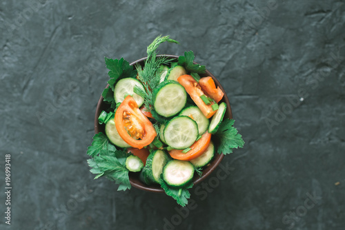 Fresh salad with vegetables on a black matte background. The concept of a healthy diet photo