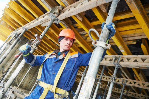 Builder installing or dismantling pole support for concrete monolithic formwork at housebuilding