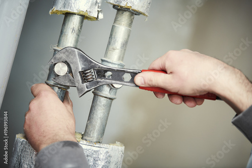 Plumber work. hand with wrench photo