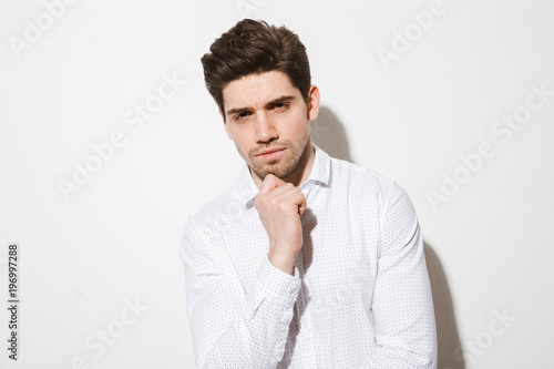 Portrait of a pensive charming man dressed in shirt