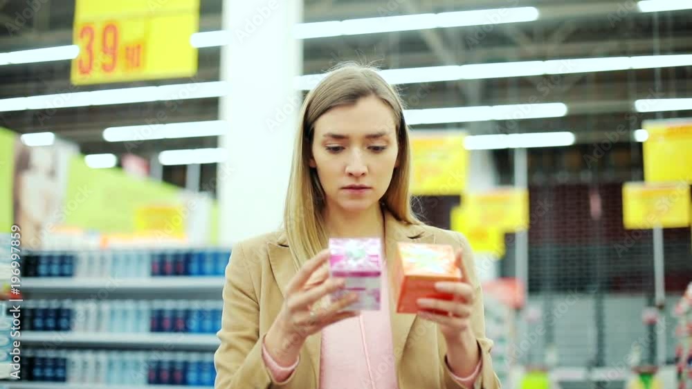 Woman in supermarket choosing cream body thinking holding girl beautiful looking choosing customer product shopper store young businesswoman buy mall elegant attractive close up portrait Woman in supermarket choosing cream body thinking holding girl beautiful looking choosing customer product shopper store young businesswoman buy mall elegant attractive close up portrait