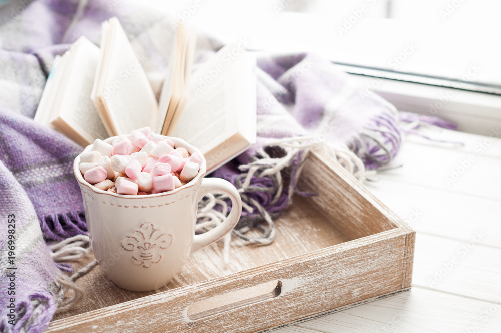 Coffee cup, open book, marshmallow and plaid on a window sill in winter. Cozy home breakfast concept Coffee cup, open book, marshmallow and plaid on a window sill in winter. Cozy home breakfast concept