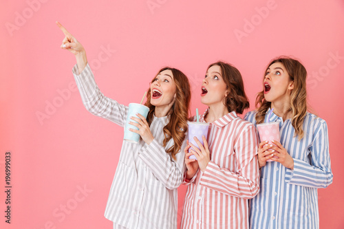 Photography Three content women with good mood in striped pyjamas smiling and looking upward