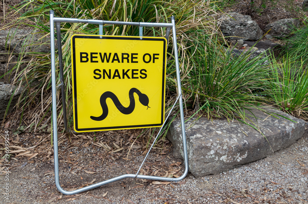Fototapeta premium Yellow beware of snakes warning sign in suburban Melbourne.