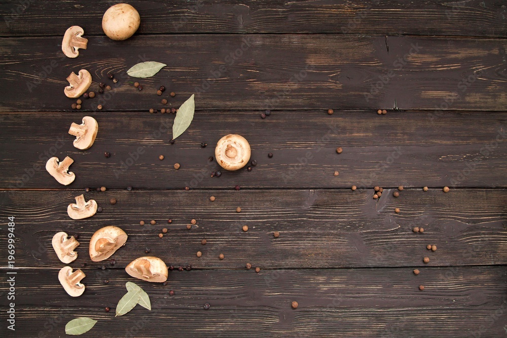 flatlay on dark wooden boards: champignons with Bay leaves and allspices flatlay on dark wooden boards: champignons with Bay leaves and allspices