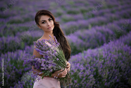 Walking women in the field of lavender.Romantic women in lavender fields. Girl admires the sunset in lavender fields. photo