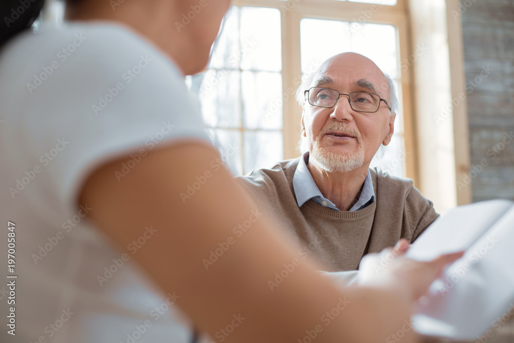 Fototapeta premium Daily routine. Smart thoughtful senior man talking while wearing glasses and looking at woman
