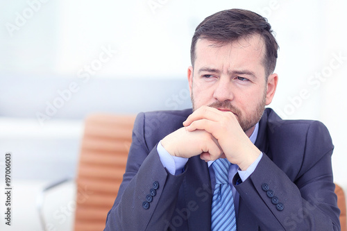 Tired business man at workplace in office holding his head on hands. Sleepy worker early in the morning after late night work. Overworking, making mistake, stress, termination or depression concept photo