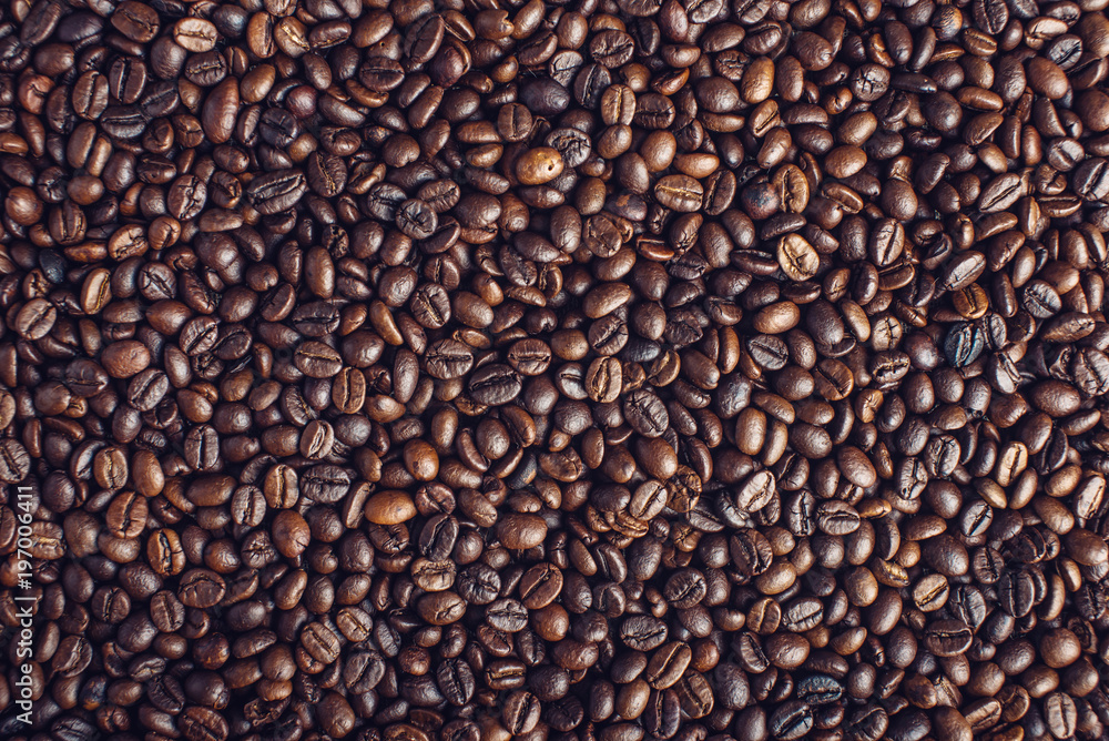 Fototapeta premium Textured background of coffee beans top view. Concept of the production of fresh aromatic drink.