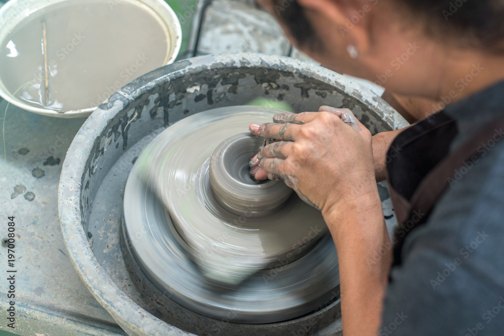 Fototapeta premium Hands working on pottery wheel