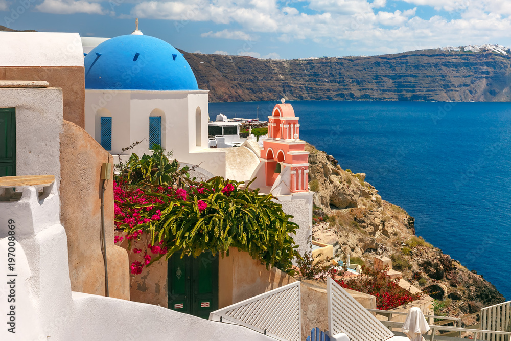 Picturesque view of white houses and church with blue domes in Oia or Ia, island Santorini, Greece