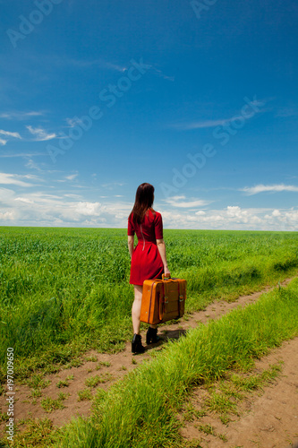 girl with suitcase at wheat field