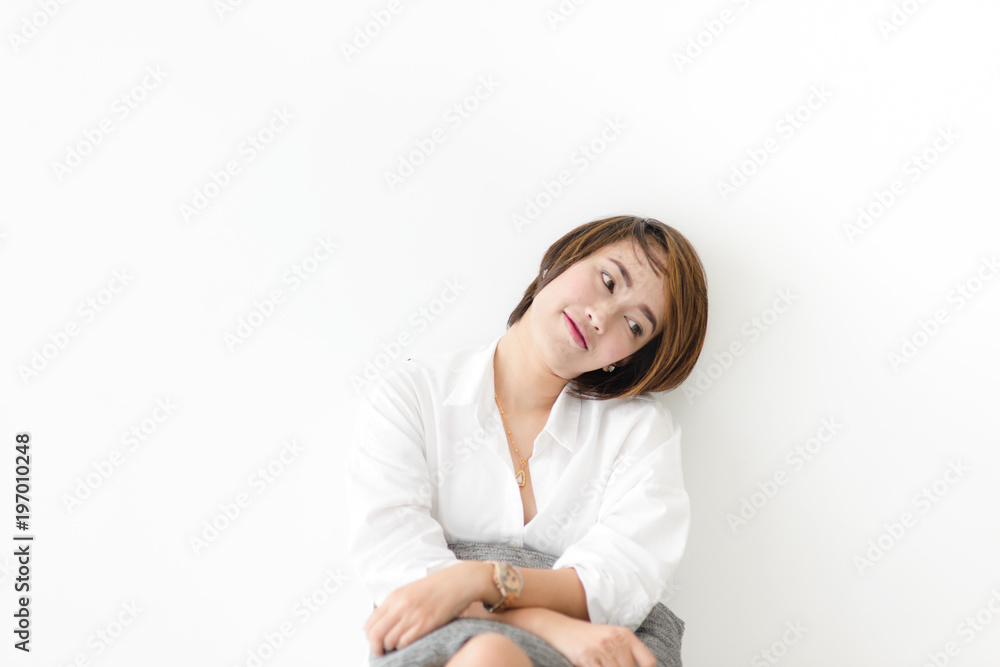 Happy Asian woman wearing white shirt sitting on floor with wall. Happy Asian woman wearing white shirt sitting on floor with wall.