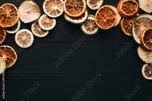 Frame of dry fruits slices on black background