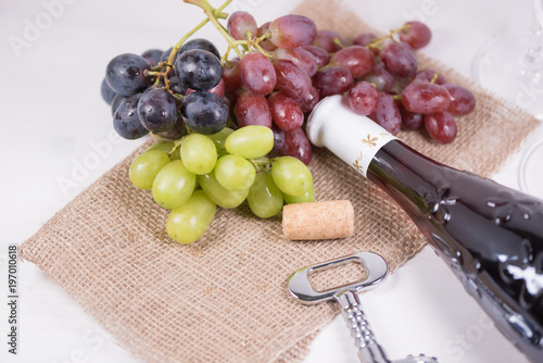 Red wine and grapes. Wine and grapes in vintage setting with corks on wooden table