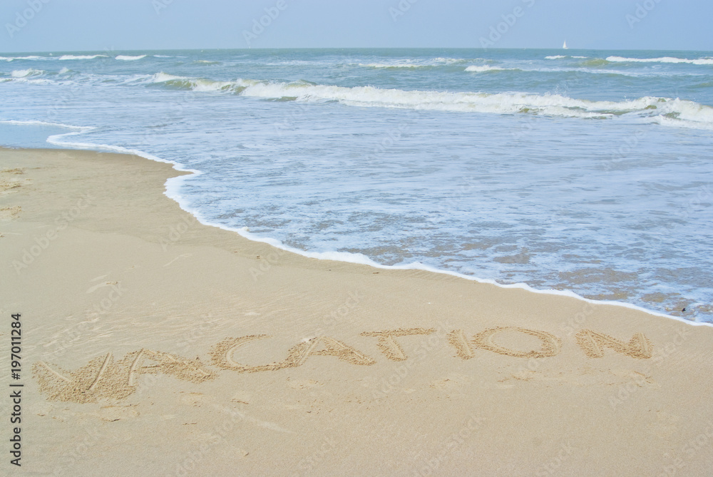 Beach with the word vacation written in the sand, summer holiday concept Beach with the word vacation written in the sand, summer holiday concept