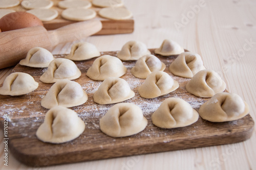 Raw Homemade dumplings with meat on the wood table, Russian Pelmeni
