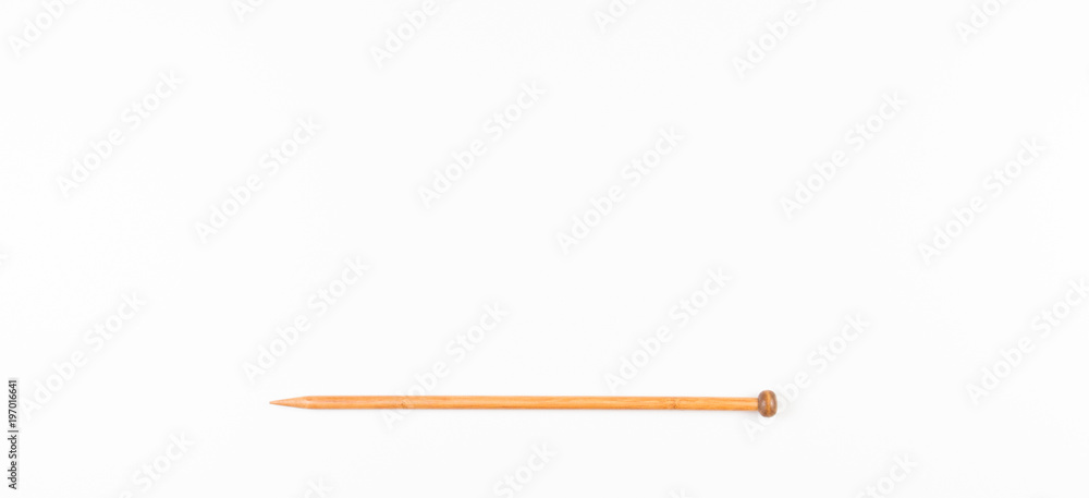 Obraz premium Wooden knitting needle on white background.