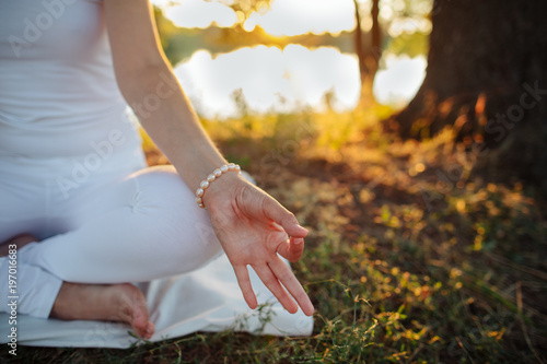  hand of a young woman are folded in a special way into a yoga mudra photo