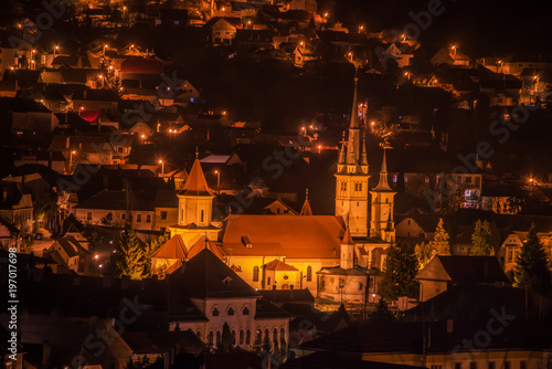 Night view from above on the city and an old building with towers. Romania. Brasov. Transylvania. Europe.
