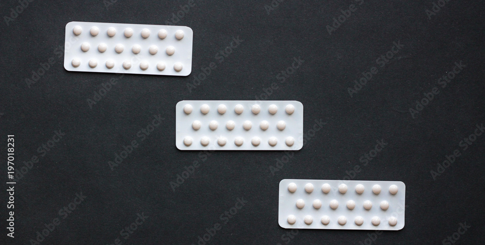 White pills on a black background, close up White pills on a black background, close up