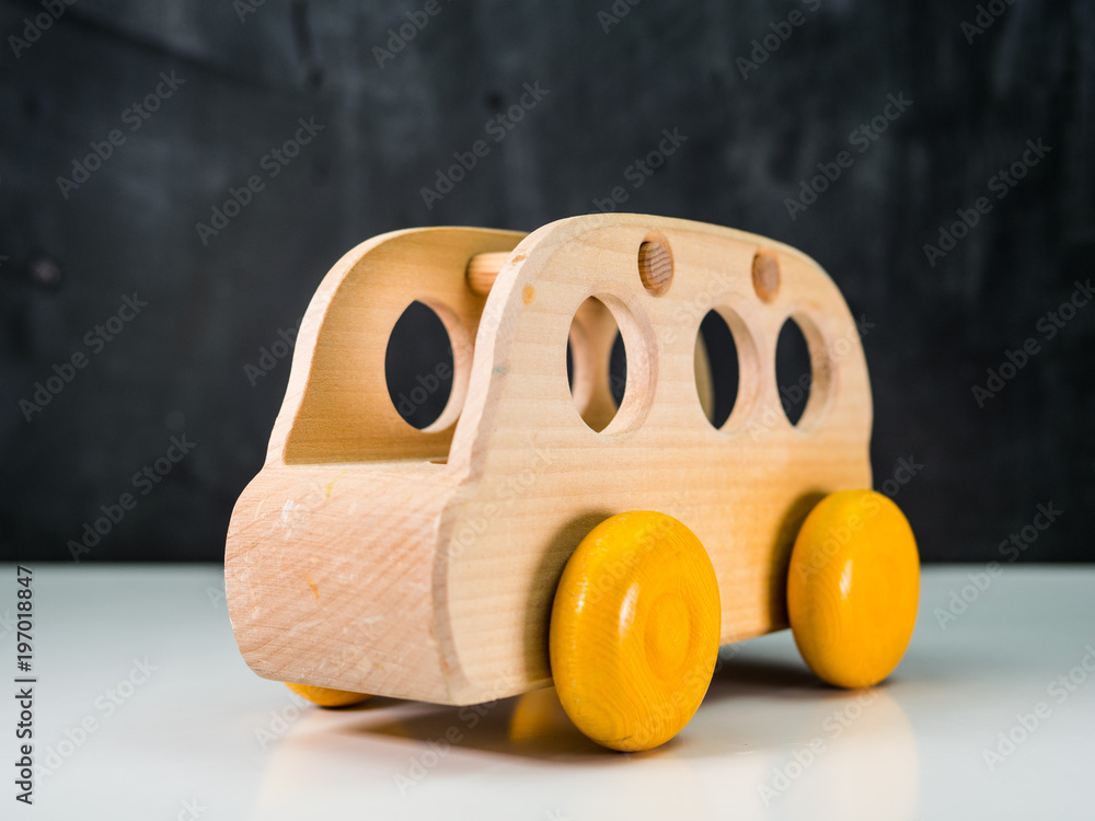 wooden toys, wooden bus, yellow wheels, chalkboard background Stock