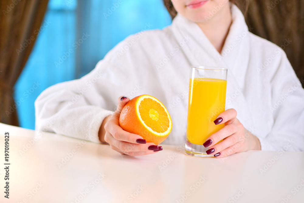 Beautiful girl holds an orange with fresh in her hands. Concept of a healthy food for beauty and health. Beautiful girl holds an orange with fresh in her hands. Concept of a healthy food for beauty and health.
