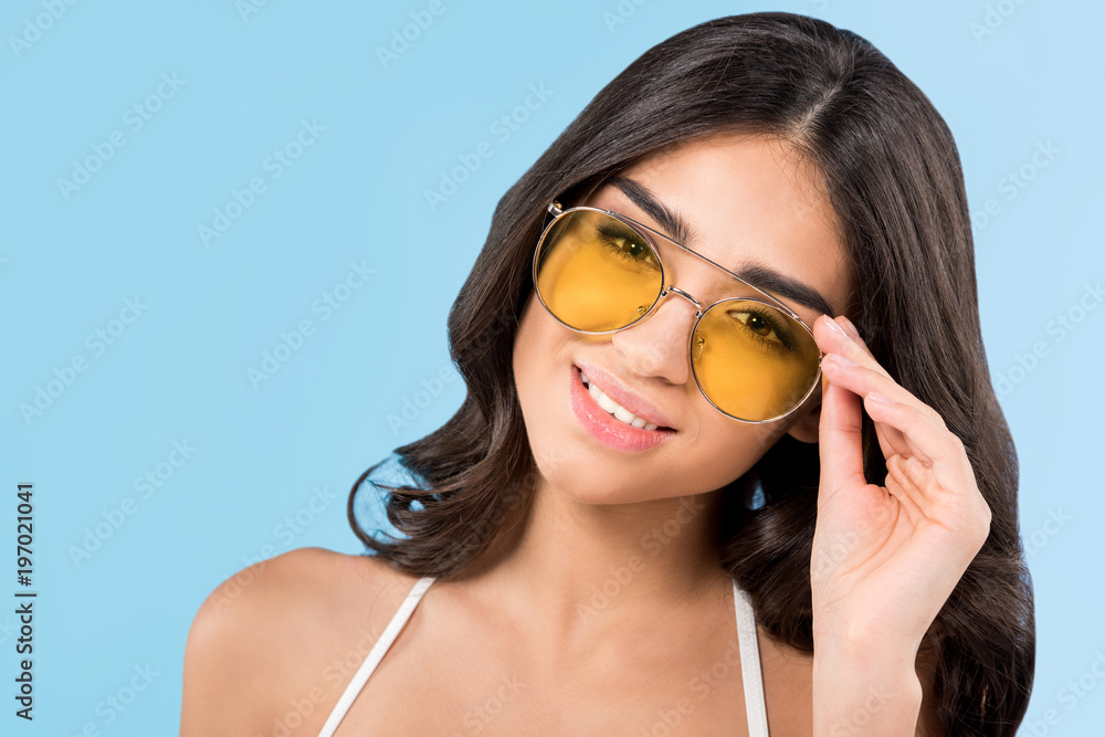 beautiful smiling girl posing yellow sunglasses, isolated on blue beautiful smiling girl posing yellow sunglasses, isolated on blue