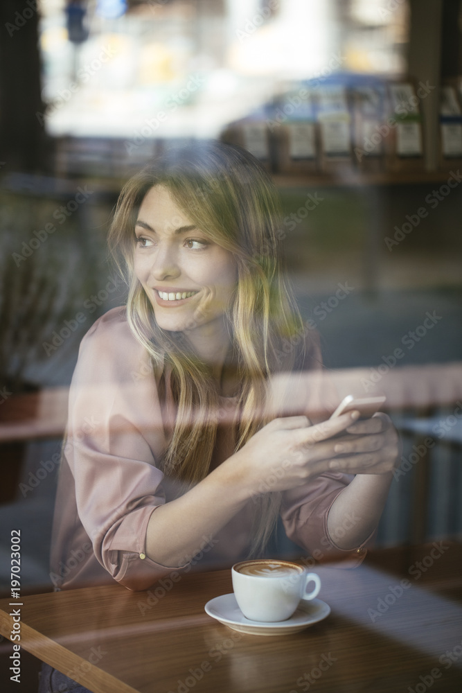 Pretty Woman Typing on Cell Phone at Coffee Shop Pretty Woman Typing on Cell Phone at Coffee Shop