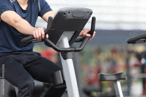 Close-up footage of a man working out in gym on the exercise bike, young man cycling in the gym. female exercising in fitness gym for good health.