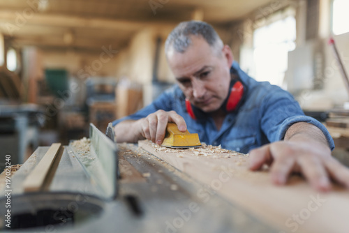 Man doing woodwork in carpentry. Carpenter work on wood plank in workshop