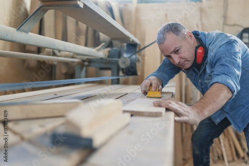 Attractive man doing woodwork in carpentry
