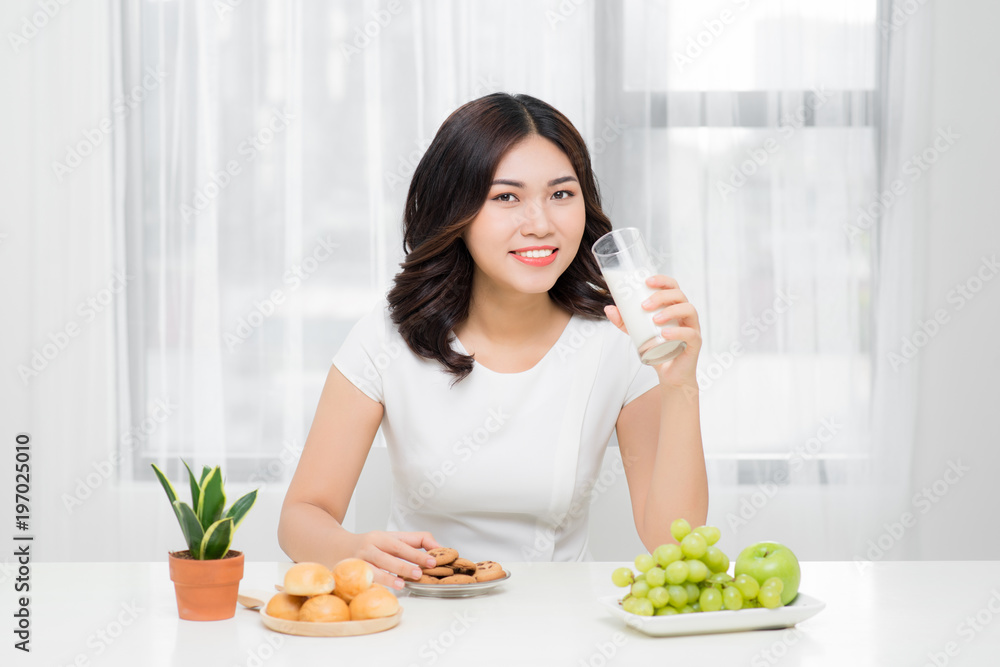 Healthy woman is drinking milk from a glass isolated on white background.