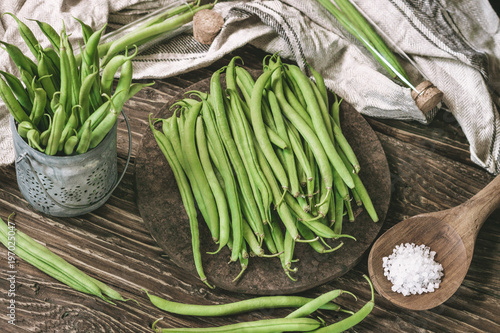 Bunch of freshly picked green beans on a rustic wooden surface. Organic and diet food.