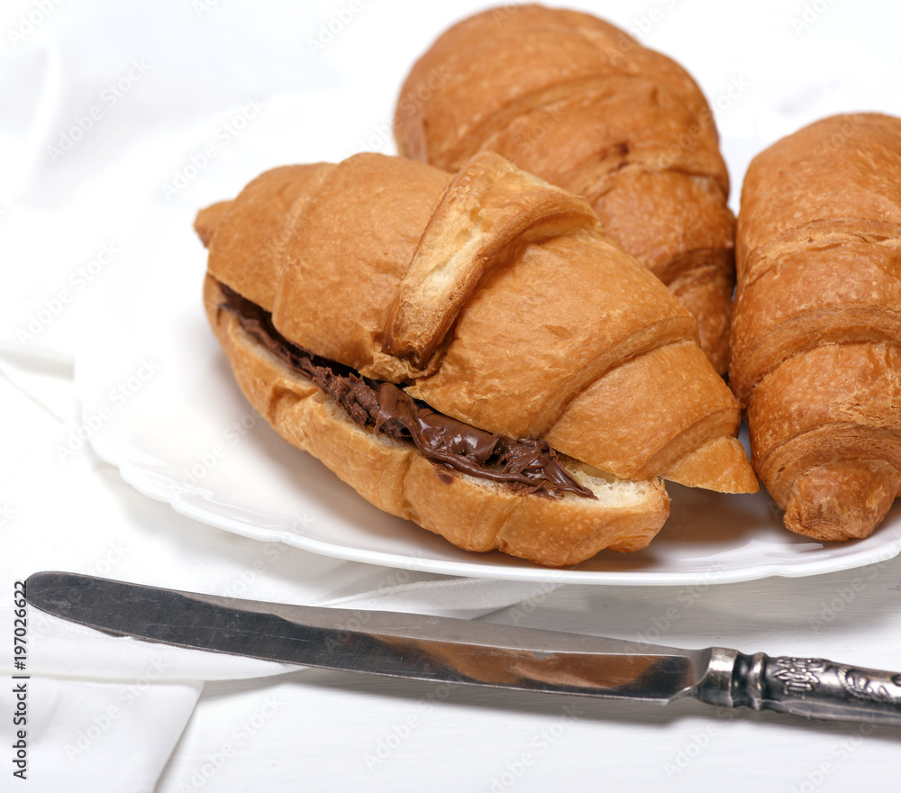 baked croissants with chocolate on a white ceramic plate baked croissants with chocolate on a white ceramic plate