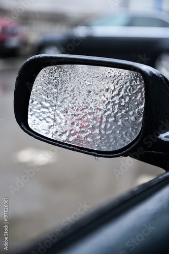 Vehicle mirror covered in ice during freezing rain